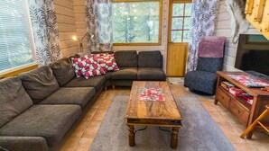 A cozy living room with a sectional sofa, a wooden coffee table, and a television.