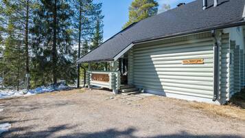 A log cabin with a wooden porch and a sign reading 'KEISPRINTUPA'.