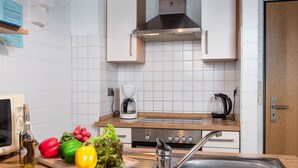 Een moderne keuken met witte kastjes, een roestvrijstalen spoelbak en een koffiezetapparaat.