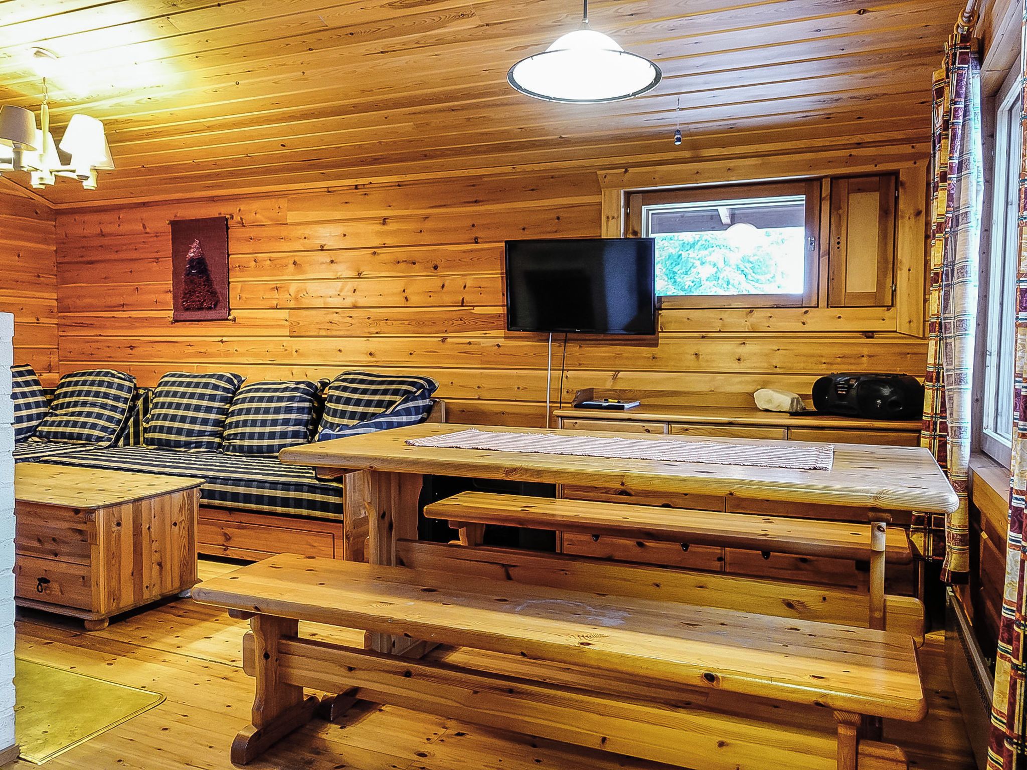 L'intérieur d'une cabine comprenant un canapé, une table, un téléviseur et une fenêtre.