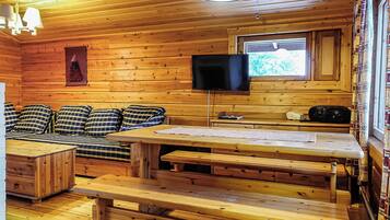 L'intérieur d'une cabine comprenant un canapé, une table, un téléviseur et une fenêtre.