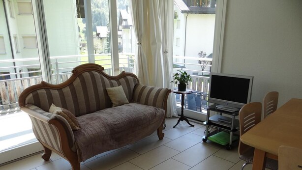 A living room with a sofa, a TV, and a dining area. - Blumenweg 10 Appartement/Fewo 6-Bettwohnung by Interhome (Engelberg)