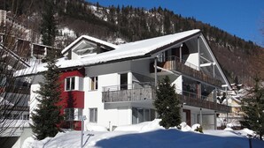 A multi-story chalet with a sloped roof, balconies, and a snow-covered landscape. - Blumenweg 10 Appartement/Fewo 6-Bettwohnung by Interhome (Engelberg)