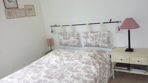 A bedroom with a bed, a nightstand, a lamp, and wall decorations. - Blumenweg 10 Appartement/Fewo 6-Bettwohnung by Interhome (Engelberg)