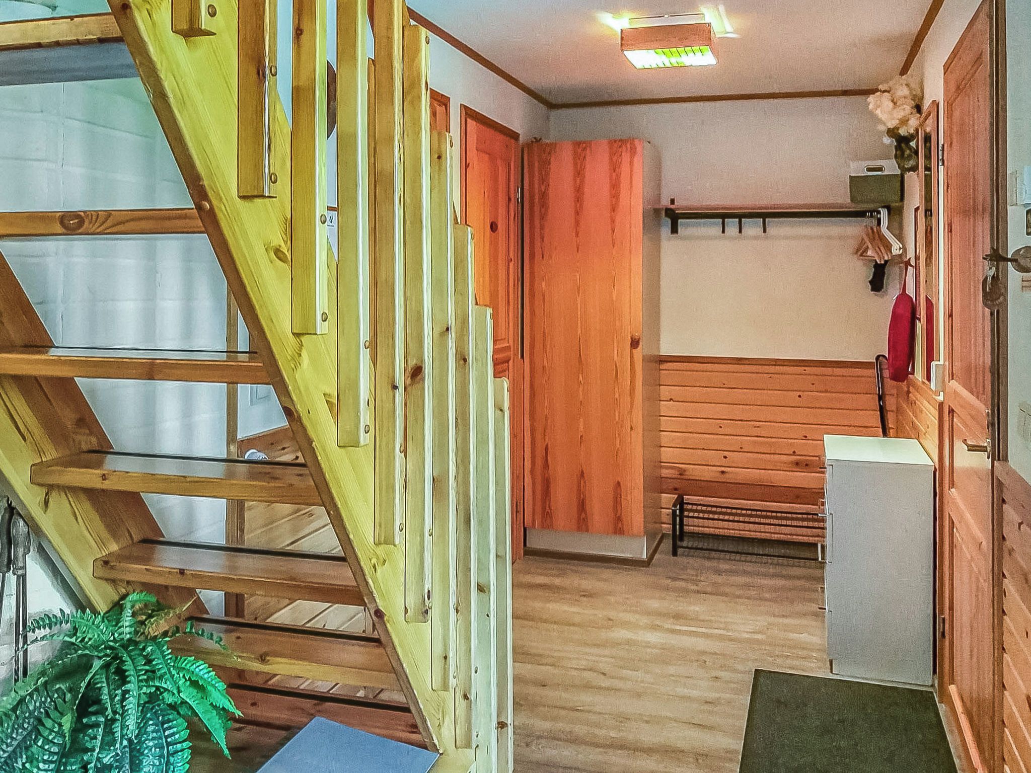 Una escalera de madera que conduce a una habitación con un banco y una mesita.