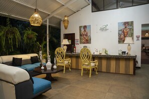 A reception area with a sofa, chairs, a reception desk, and wall art.