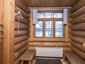 A log cabin interior with a wooden bench, a radiator, and a window with curtains. - Palkinniemi by Interhome (Punkaharju)
