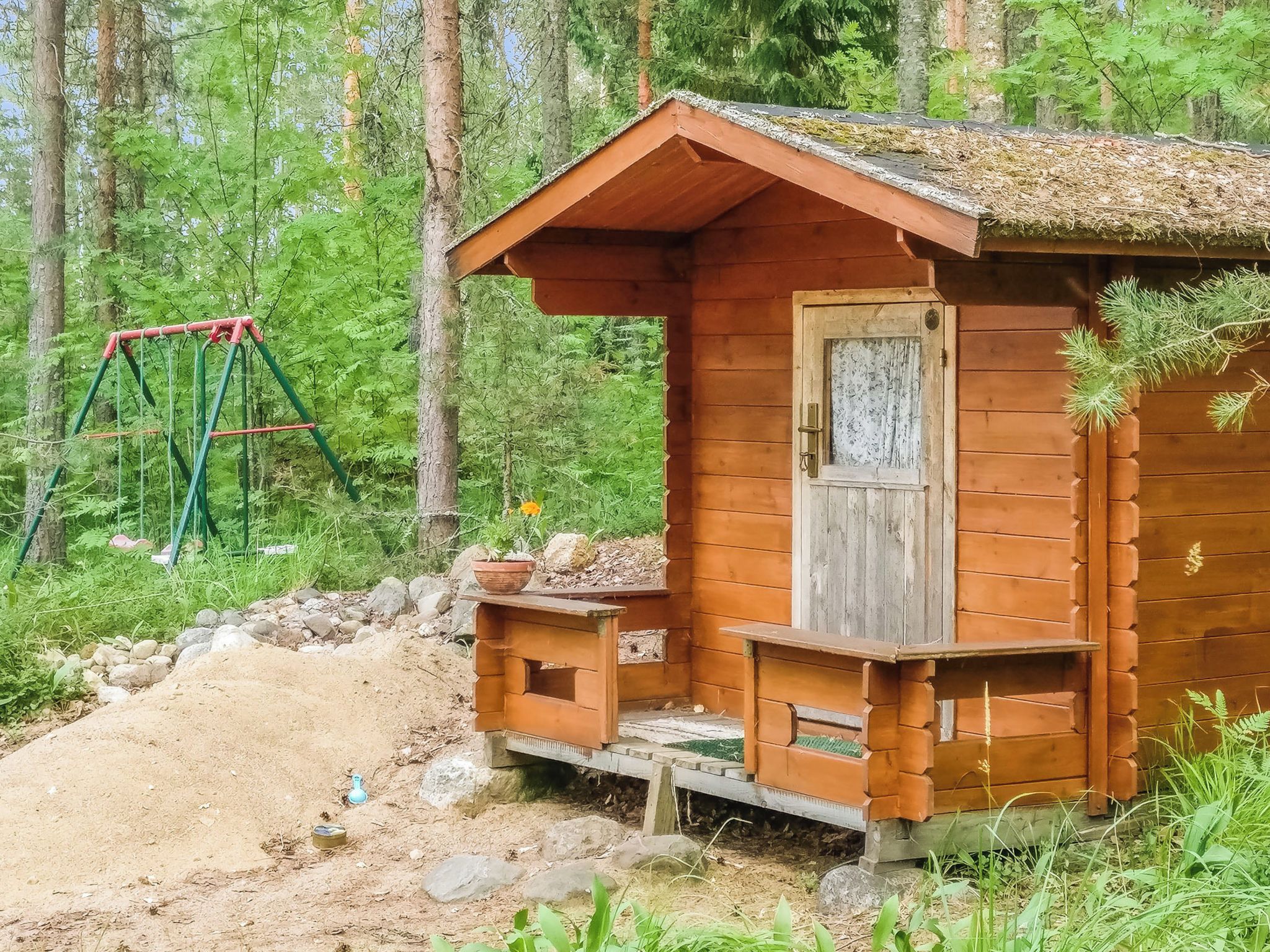 Ein rustikales Holzhaus mit Veranda, umgeben von einem Wald.