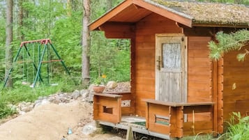 Ein rustikales Holzhaus mit Veranda, umgeben von einem Wald.