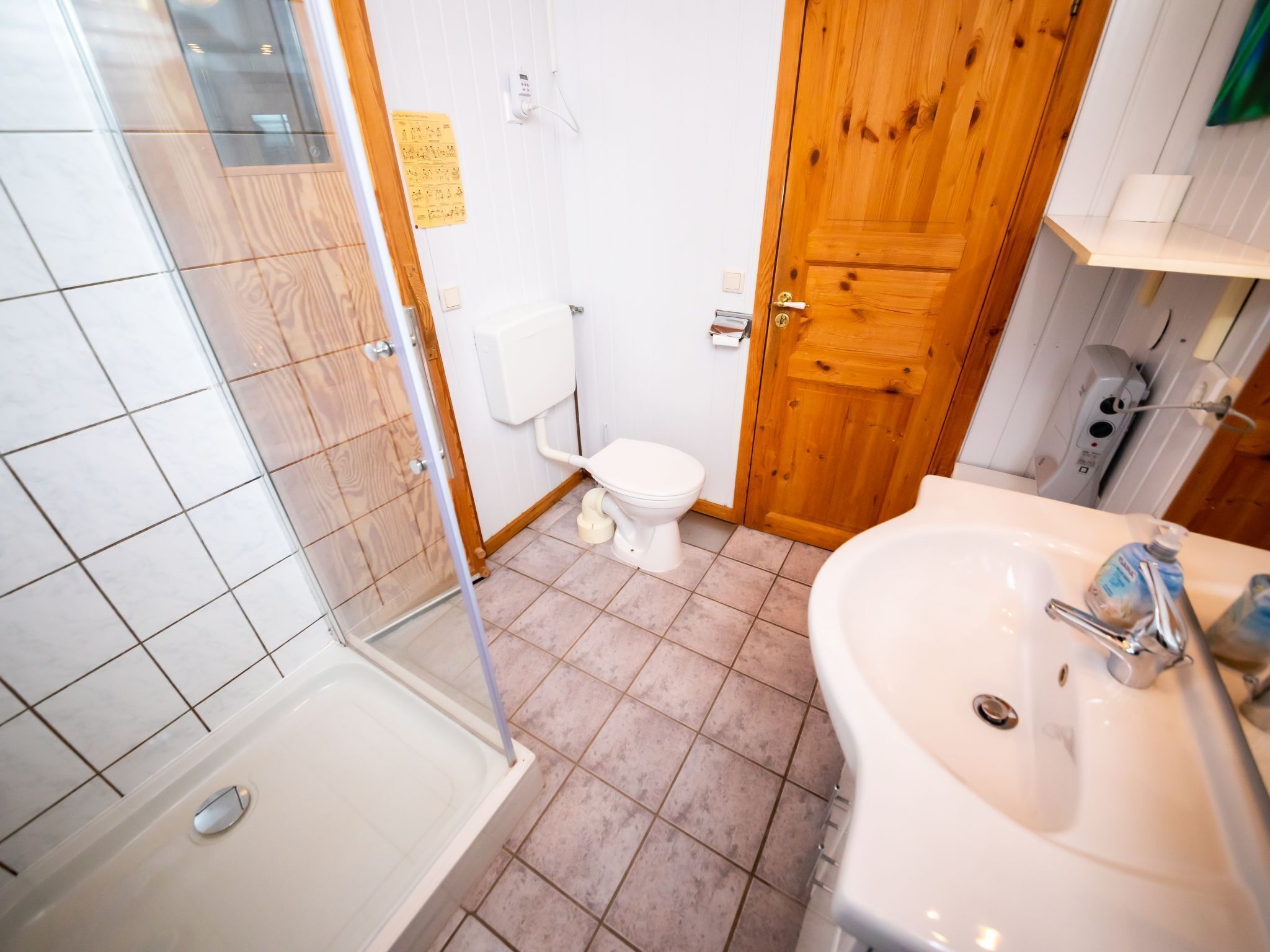 A bathroom with a shower, toilet, and sink.