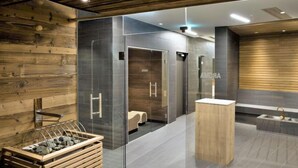 Ein modernes Badezimmer mit Holzboden, einer Duschkabine aus Glas und einem Holzbadezimmer-Möbel.