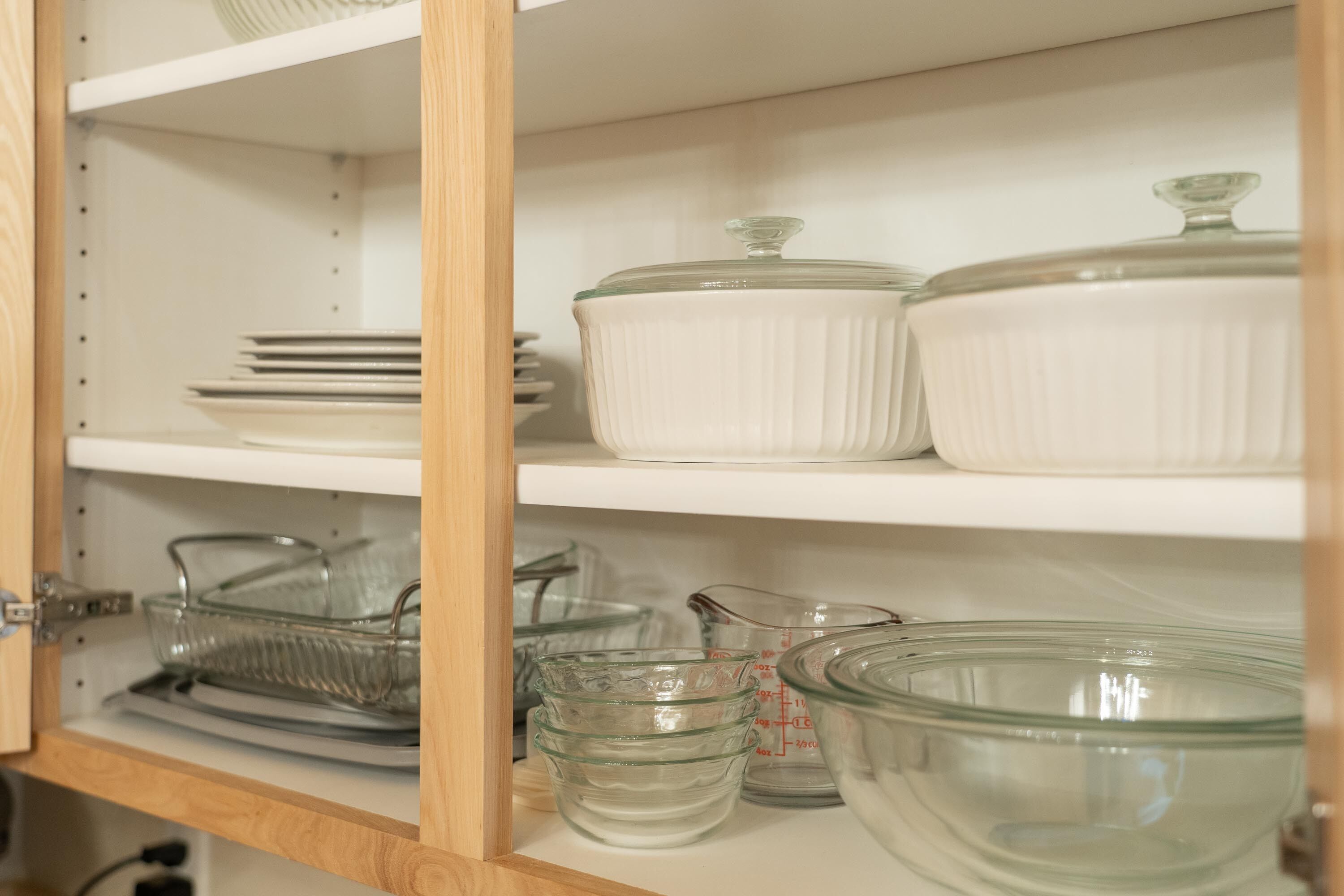 Un mueble de cocina con cristalería y vajilla.