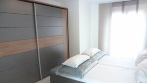 A bedroom with a bed, a wardrobe, and a window with curtains. - Apartment Brake by Interhome (Offenburg)