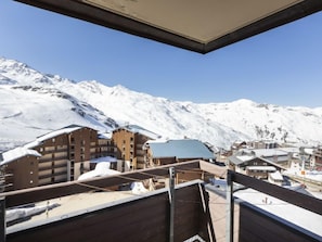 Un paysage montagneux enneigé, avec des bâtiments en bois et un ciel dégagé.