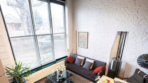 A modern living room with a sofa, a glass coffee table, and a fireplace. - Holly Lodge Coach House by Interhome (London West)