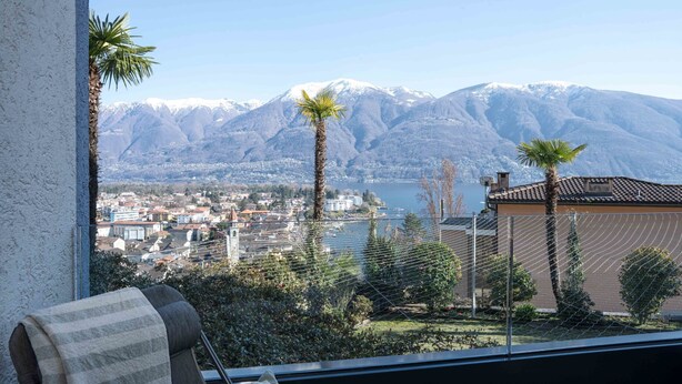 A balcony with a view of a town, mountains, and a lake. - Double Room Classic by Interhome (Ascona)