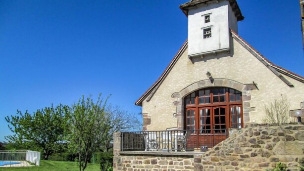A stone building with a small tower, a large arched window, and a balcony. - La Grange by Interhome (Gramat)