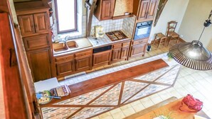 A kitchen with wooden cabinets, a sink, and a stove. - La Grange by Interhome (Gramat)