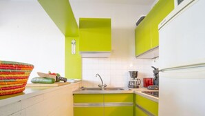 A kitchen with green cabinets, a sink, and a coffee maker. - Le Grand Pavois by Interhome (Port Camargue)