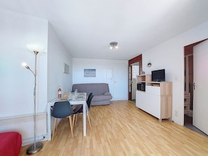 Un espace de vie compact comprenant un coin repas, une kitchenette et un canapé.