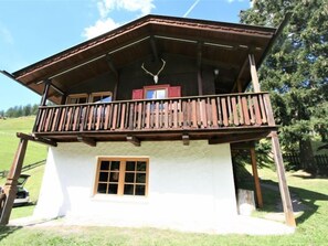 Una baita con un balcone, una porta in legno e una finestra.