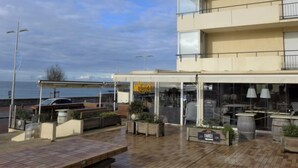En restaurant ved vandet med udendørs siddepladser, en overdækket terrasse og havudsigt.