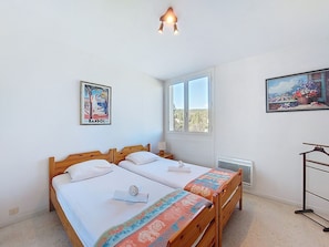 A hotel room with two beds, a window with a view, a radiator, and a painting on the wall. - La Calanque d'Or by Interhome (Bandol)