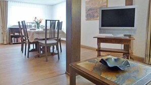 A living room with a dining area, a flat-screen TV, and a wooden coffee table. - Vacation home Roth by Interhome (Ichenheim)