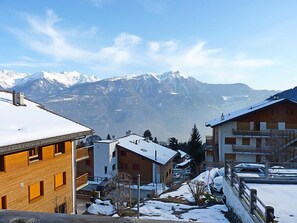 A residential area with snow-covered roofs and mountains in the background. - Seya 19 by Interhome (Ovronnaz)