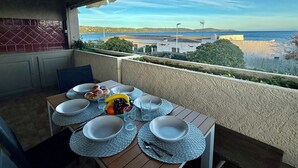 Un balcón con una mesa dispuesta para el desayuno y vistas al mar.