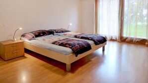 Une chambre à coucher avec un lit, une table de chevet et une fenêtre avec des rideaux.