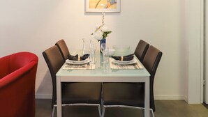A dining table with four chairs, a vase with flowers, and a framed picture on the wall. - Matten (Utoring) by Interhome (Zermatt)