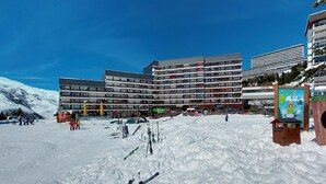 A multi-story hotel with a modern architectural design, featuring a ski slope in the foreground. - Chavière 832 by Interhome (Les Menuires)