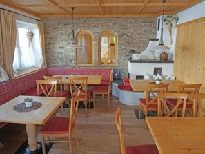 A cozy restaurant with wooden tables and benches, stone walls, and a fireplace. - Apartment Ladis by Interhome (Fiss)