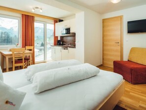 A hotel room with a bed, a desk, a chair, a kitchenette, and a TV. - Apartment Ladis by Interhome (Fiss)