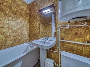Un baño con bañera, lavamanos e inodoro.
