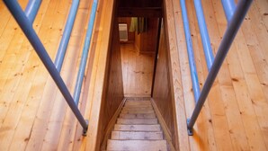 Una scala in legno con corrimano in metallo che conduce a una stanza con una finestra e una porta.