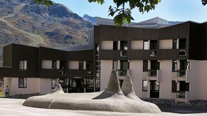A modern building with a unique architectural design featuring a central rock-like structure.