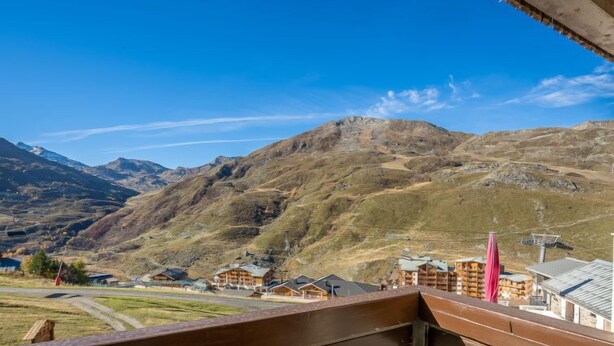 A mountain resort with wooden buildings and a clear view of the surrounding hills.