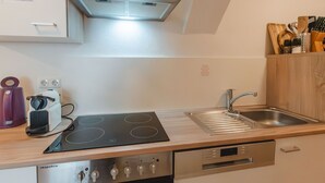 Una cocina moderna con estufa integrada, horno y pileta de acero inoxidable.