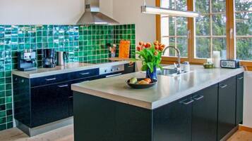 Kjøleskap, ovn, oppvaskmaskin og høy barnestol