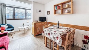 Ein gemütliches Wohnzimmer mit Essbereich, Fernseher und Bücherregal.