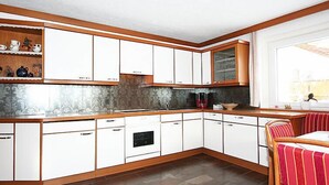 A modern kitchen with white cabinets, a wooden countertop, and a built-in oven. - Apartment Fabian by Interhome (Kaltenbach)
