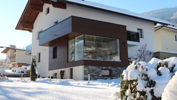 A modern two-story house with large windows and a stone facade. - Apartment Fabian by Interhome (Kaltenbach)