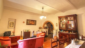 Un salon chaleureux avec une cheminée, un coin repas et une bibliothèque.
