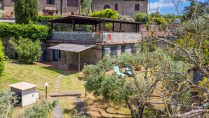 Een stenen gebouw met een overdekt terras en een tuin.