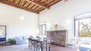 Un vaste espace de vie comprenant une table à manger en bois, un canapé et un meuble.