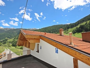 Enjoy a view of the lush valley and distant mountains from the balcony of this charming building.