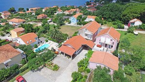 A residential area with houses, a swimming pool, and a view of the sea.