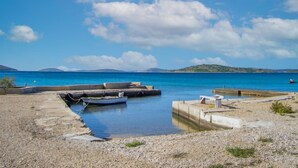 Una zona costanera amb barques amarrades, cel serena i aigua tranquil·la.
